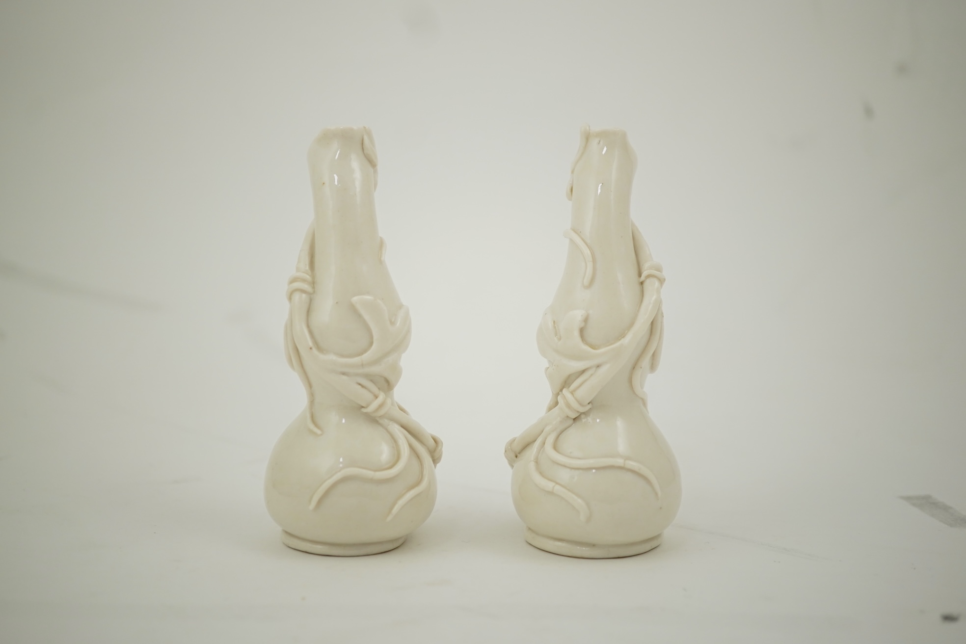 A pair of Chinese blanc-de-chine gourd-shaped vases, Dehua kilns, Qing dynasty